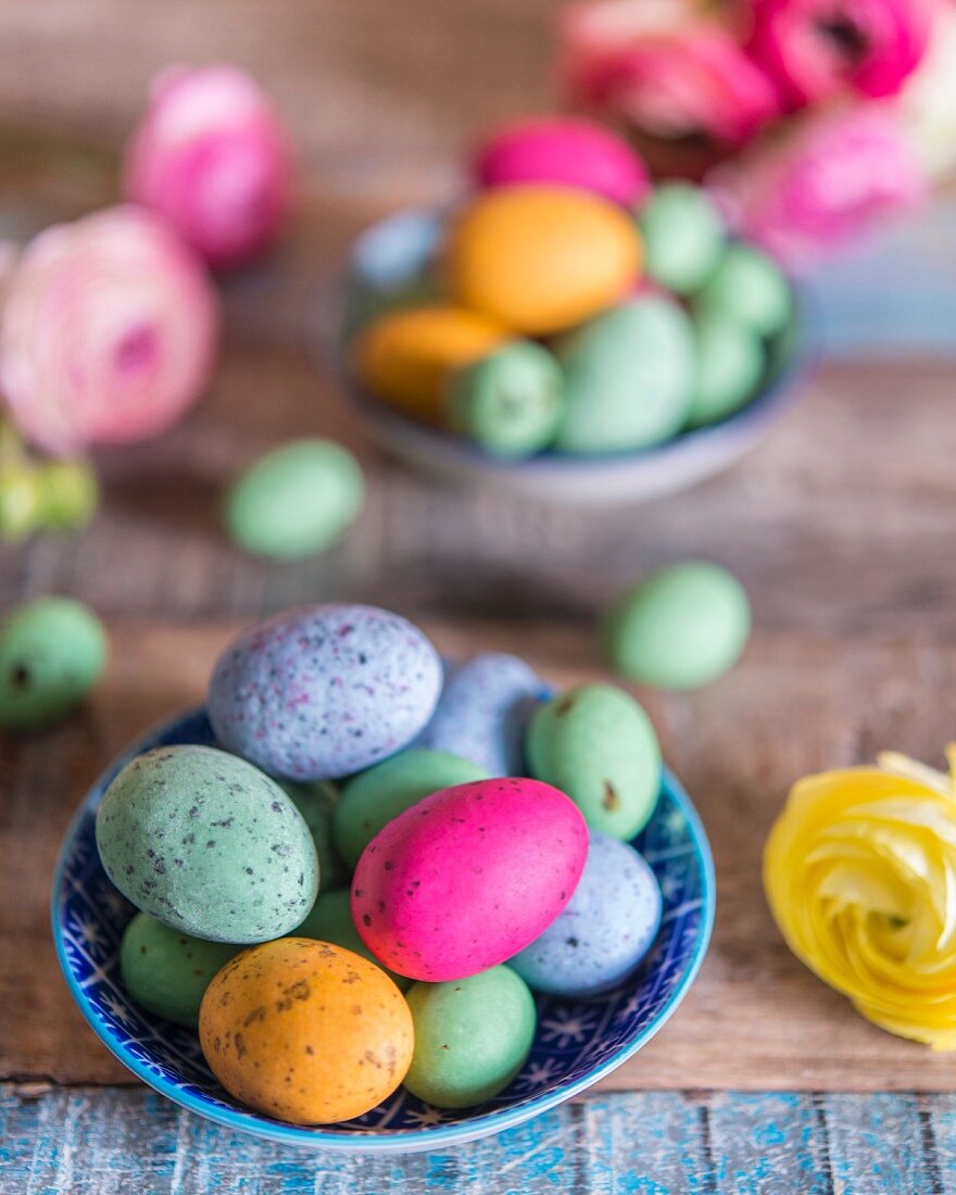 Colourful speckled eggs in bowls