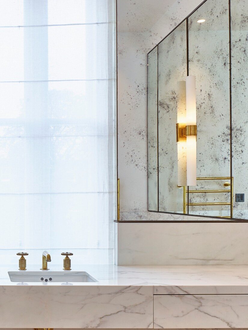 Moderner Glamour im Badezimmer mit Marmor, Gold und Spiegel