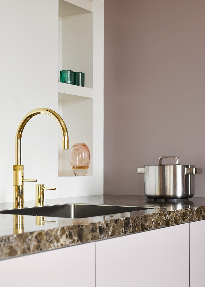 Goldene Armaturen an der Spüle in minimalistischer Küche