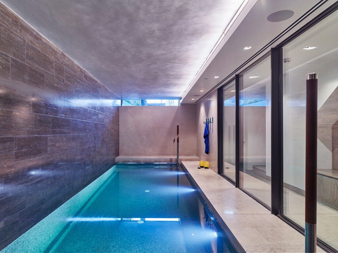 Elegant indoor swimming pool with glass sliding walls