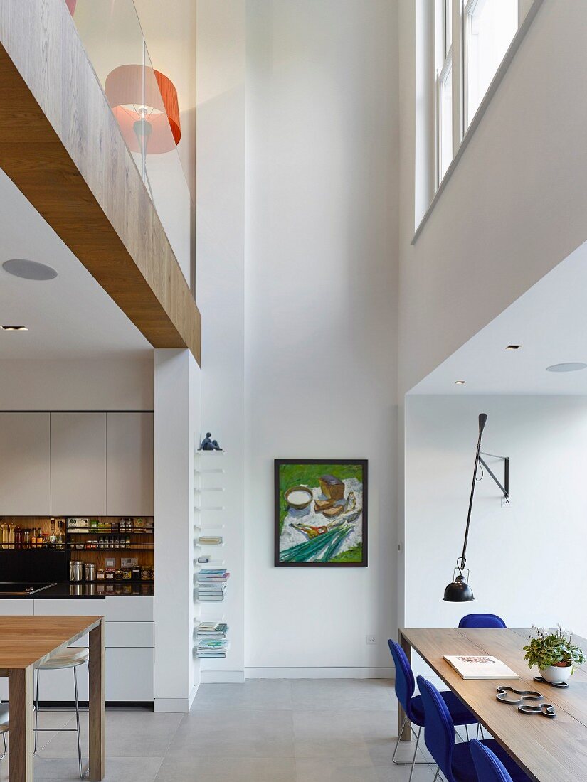 Offene Küche mit Essbereich in hohem Raum mit Galerie