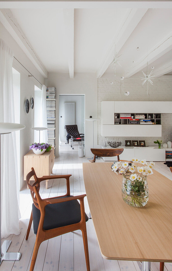Esstisch mit Designerstühlen im offenen Wohnraum