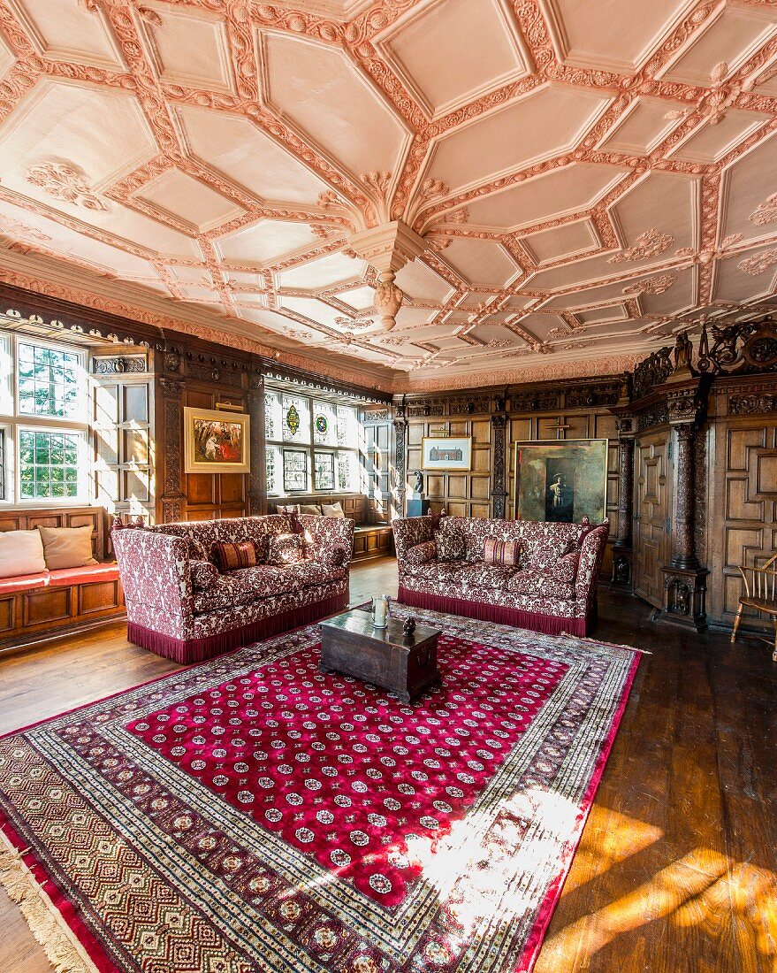 Wood-panelled walls and ornate stucco ceiling in grand living room