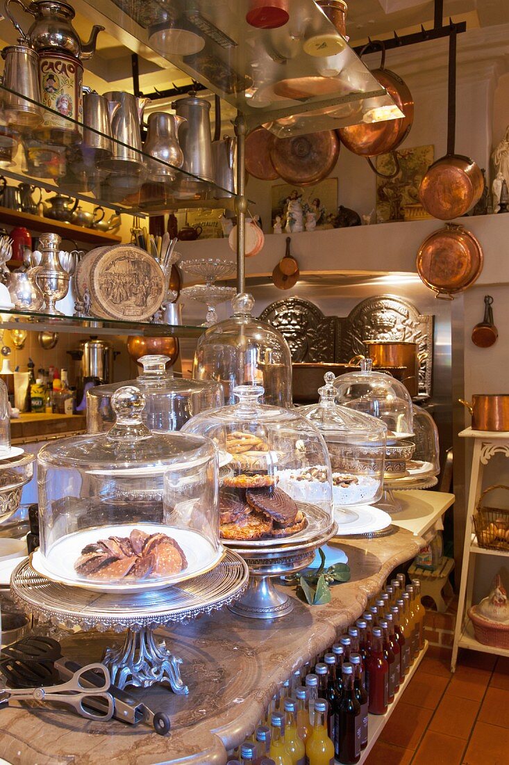 Pastries on cake stands with glass covers on counter