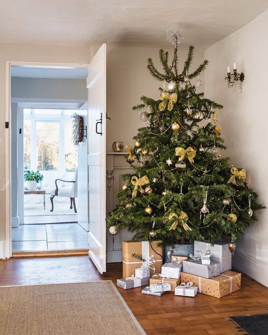 Graue und braune Geschenke unterm Weihnachtsbaum im Flur