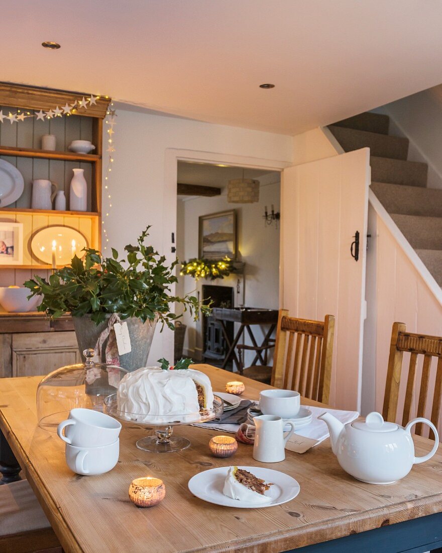 Für Kaffee und Kuchen gedeckter Tisch mit Kerzenlicht im Cottage