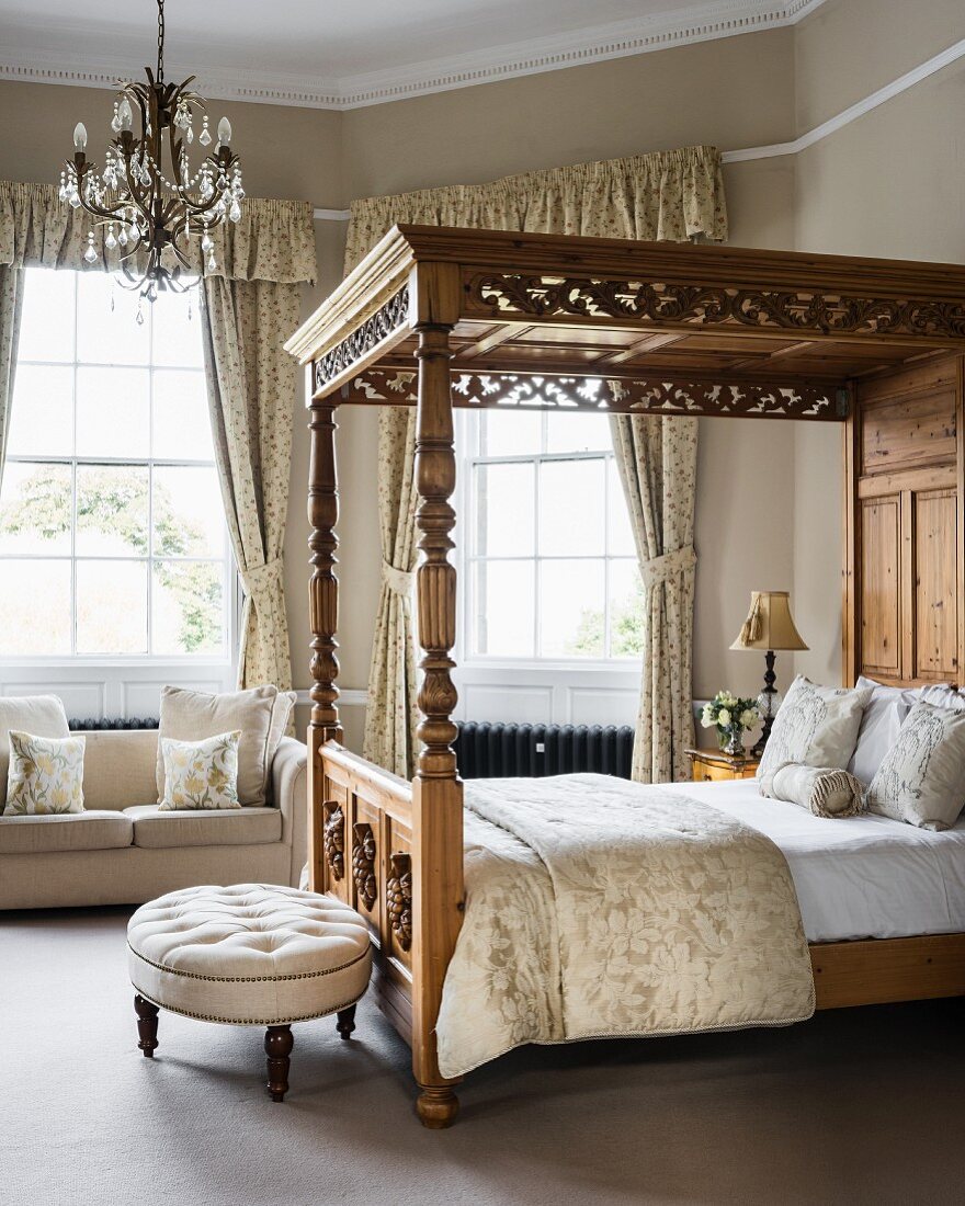 Doppelbett mit Schnitzerei und Polsterhocker in elegantem Schlafzimmer mit Erker