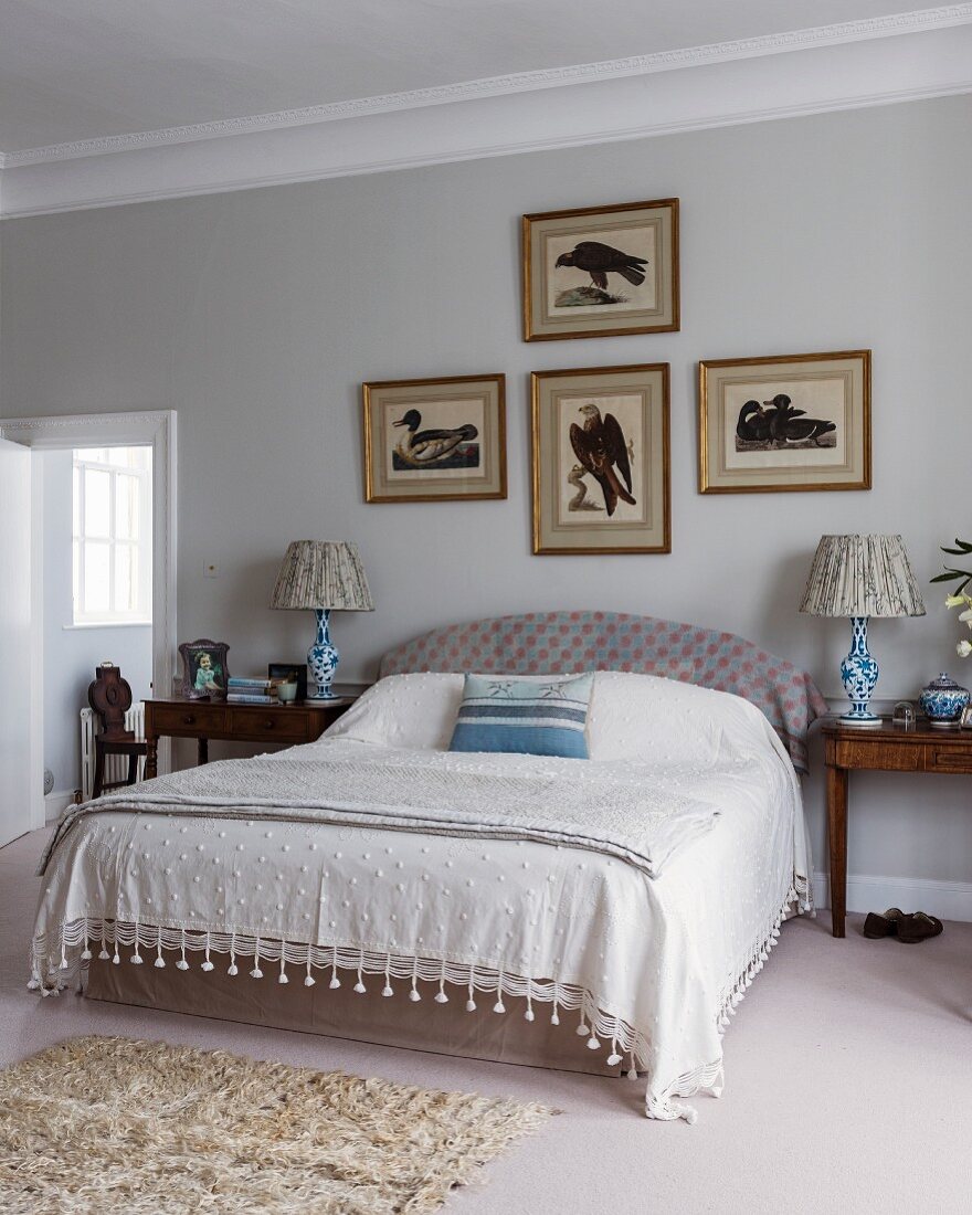 Pictures of birds above bed in classic bedroom