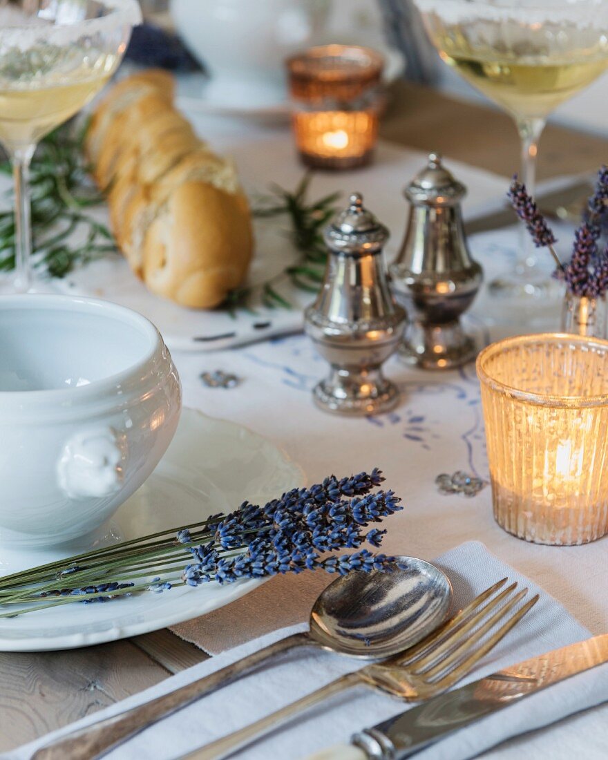 Festlich gedeckter Tisch mit Lavendelblüten und Windlichtern