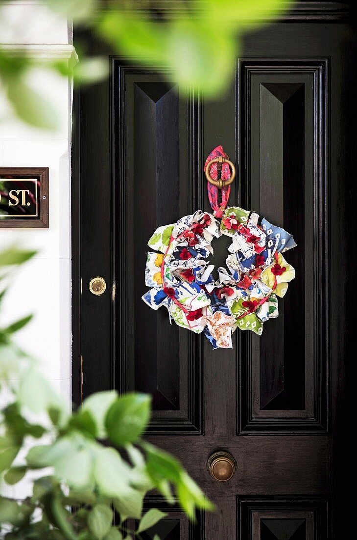Wreath of brightly patterned fabrics on a black front door
