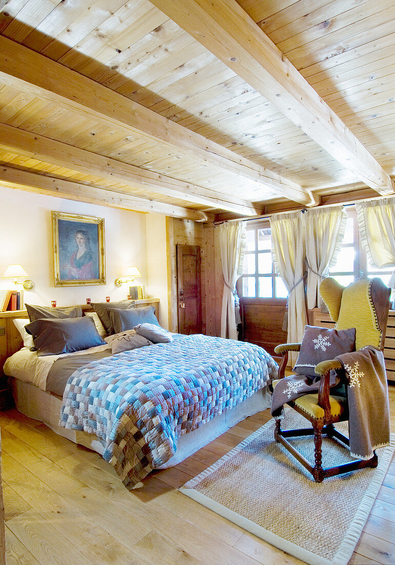 Rustikales Schlafzimmer mit Holzbalkendecke und Sprossenfenstern