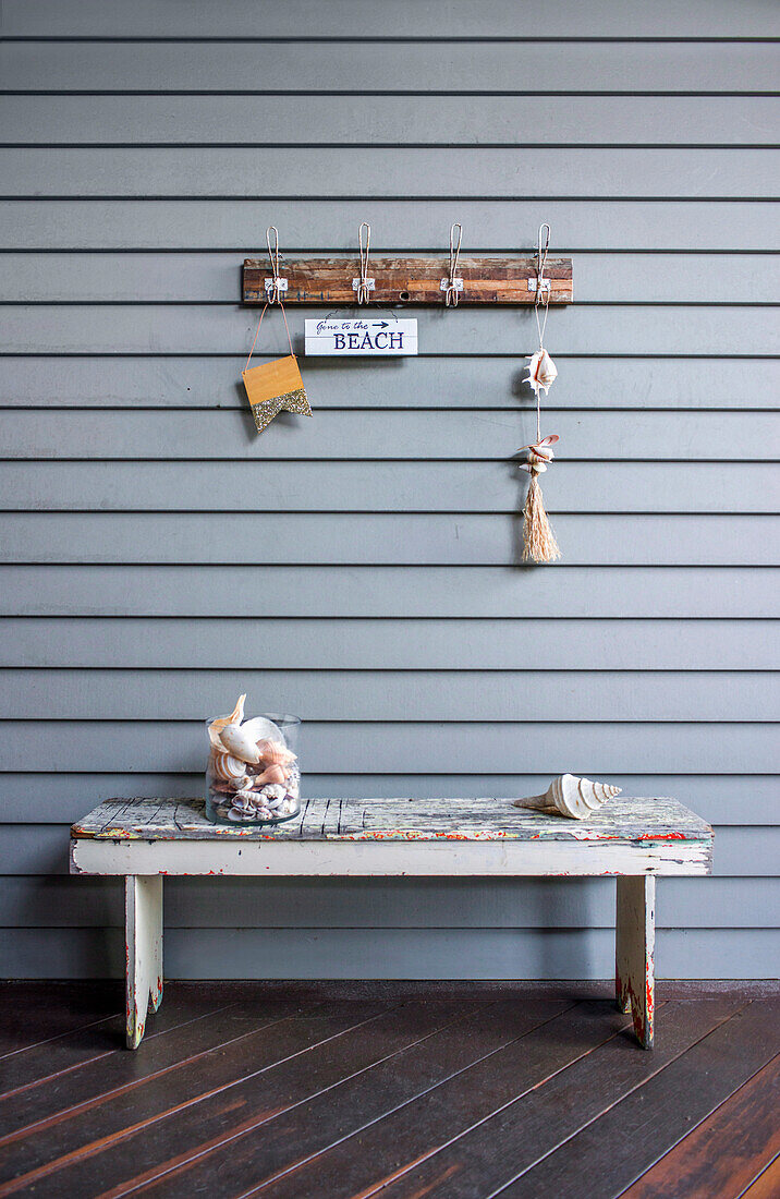 Rustic wooden bench and wall hooks with maritime decoration
