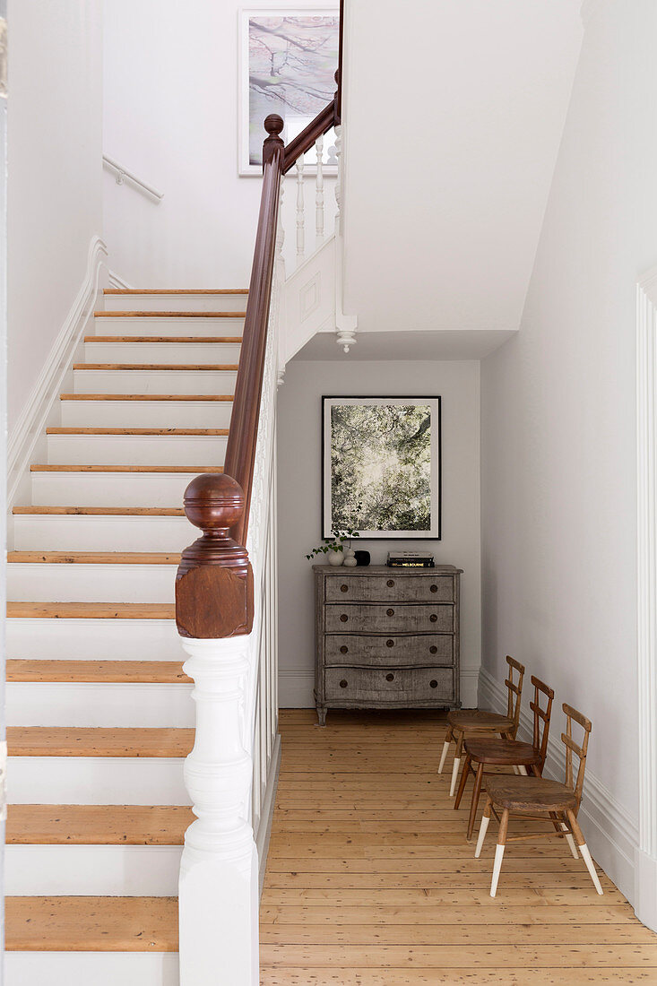 Children's chairs with painted legs and chest of drawers under the stairs