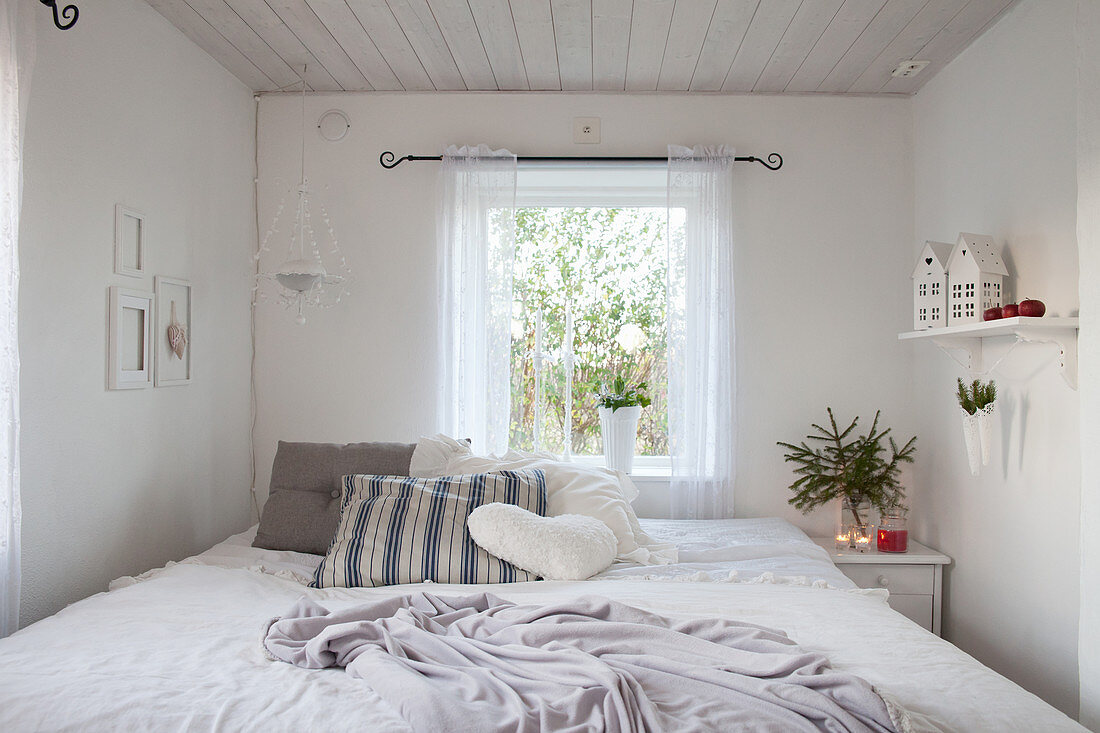 Kleines Schlafzimmer ganz in Weiß mit winterlicher Deko