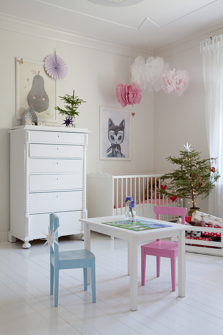 Children's table and chairs and small Christmas tree in white nursery
