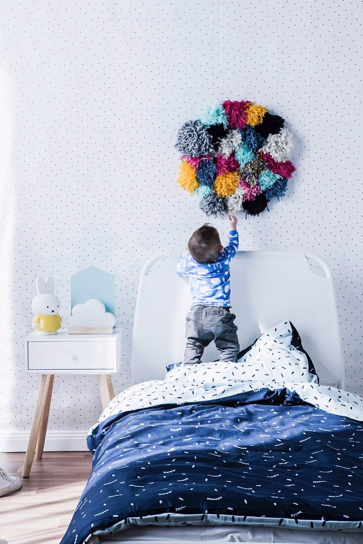 Kinderzimmer mit Punktemuster und Wanddeko aus bunten Pompons