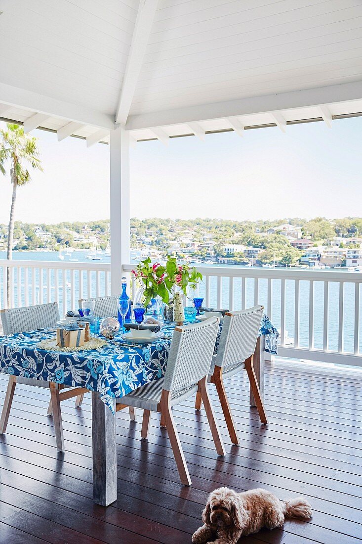 A table laid in blue and white on a summery terrace