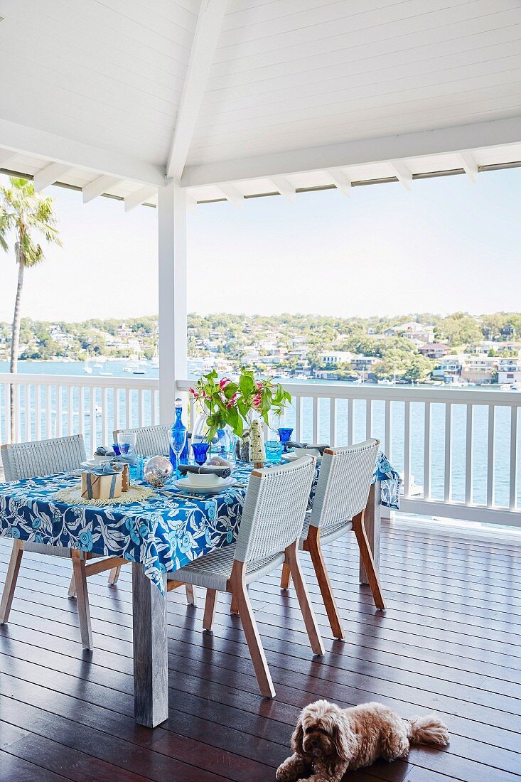 In Blau und Weiß gedeckter Tisch auf einer sommerlichen Terrasse