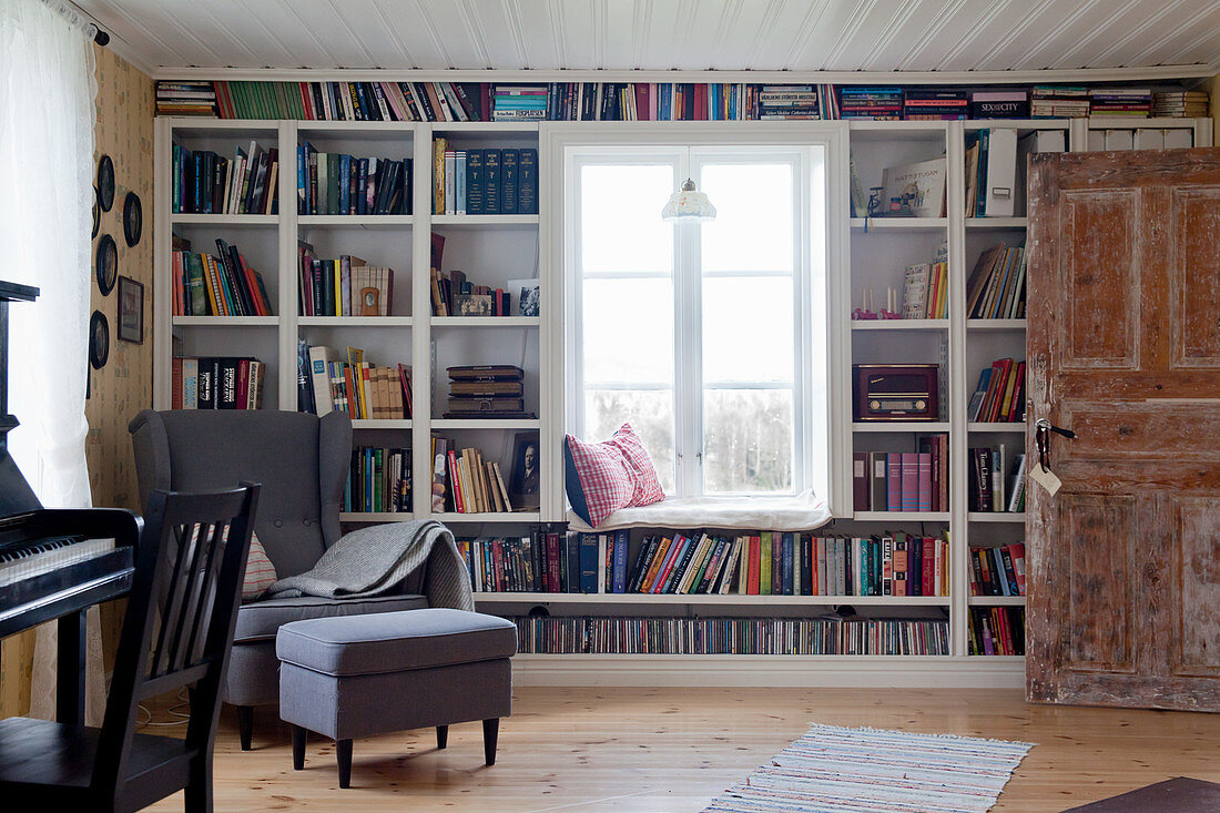 Bücherwand um das Fenster mit Sitzbank im Wohnzimmer