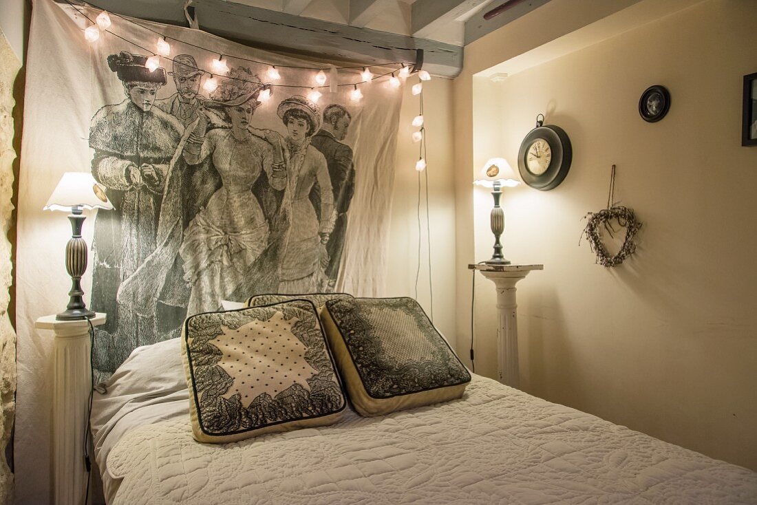 Nostalgisches Schlafzimmer mit Lichterkette, antiken Nachttischlampen und Wanddekoration