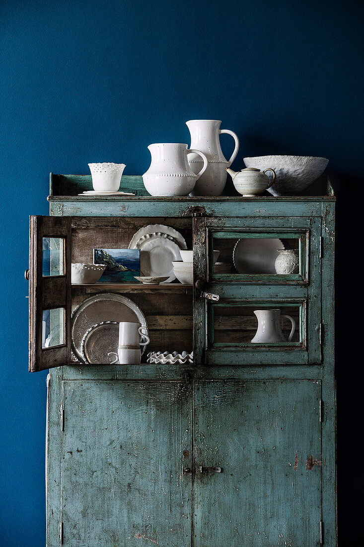 Porcelain collection in a blue vintage buffet cabinet