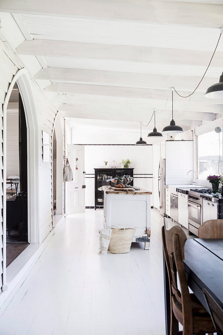 Open, white kitchen with vintage furnishings in a former church