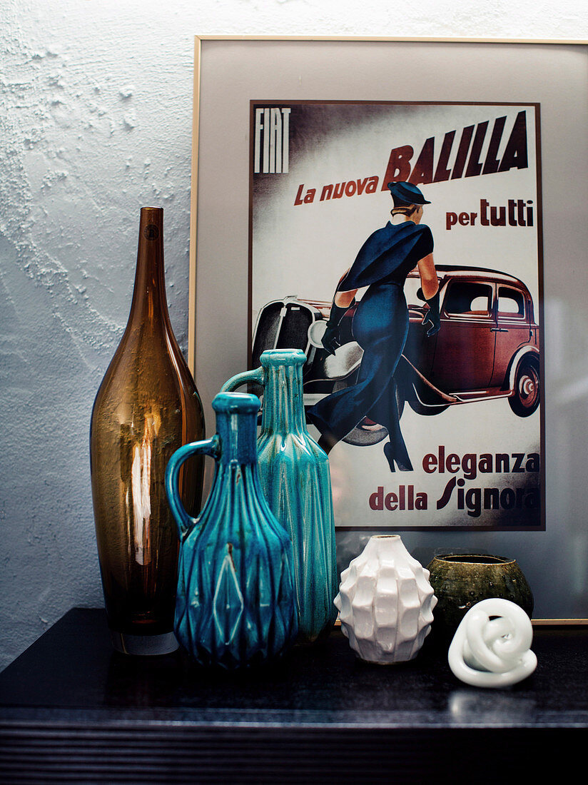 Dekoobjekte, Vase und Keramikkrüge vor Retro Werbeplakat