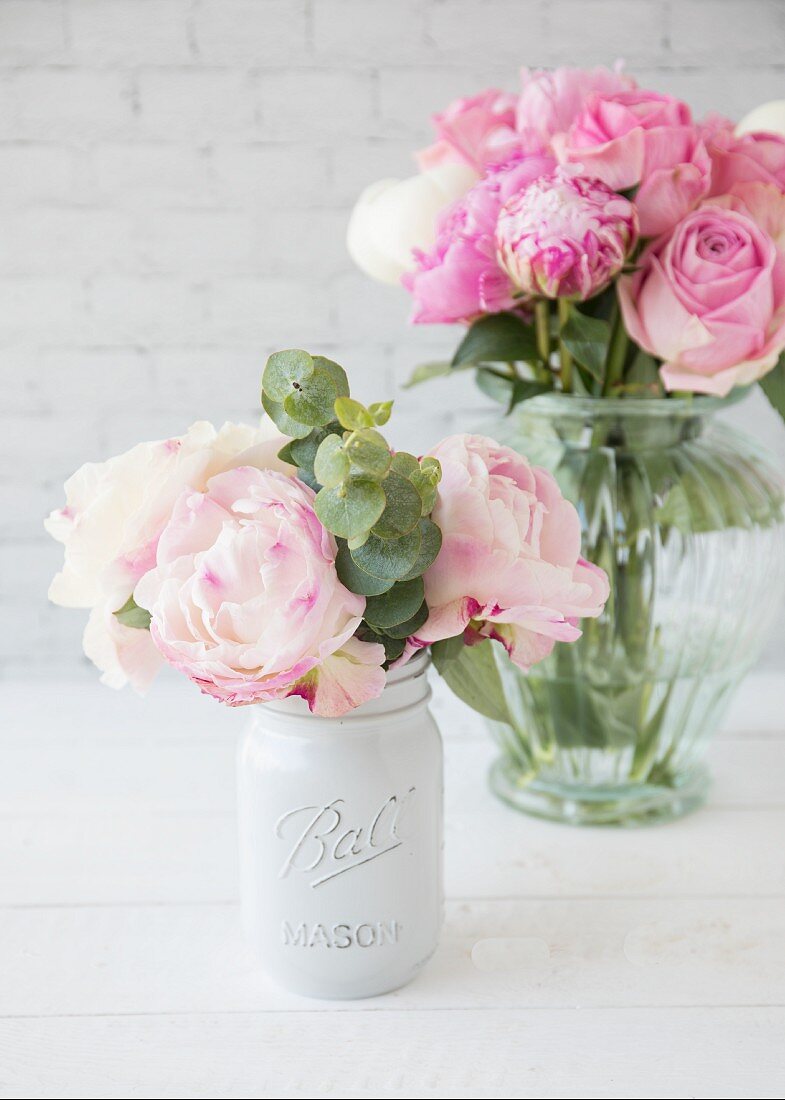 Rosa Pfingstrosen in zwei Vasen