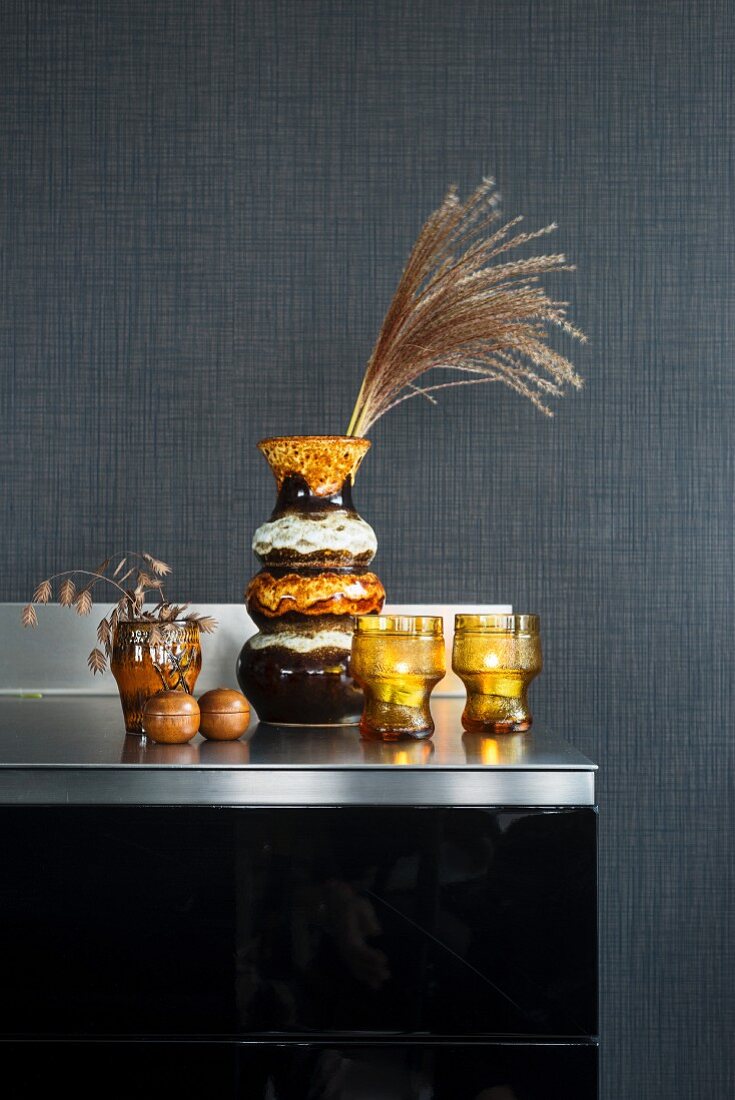 Old seventies vases and glasses against grey wall