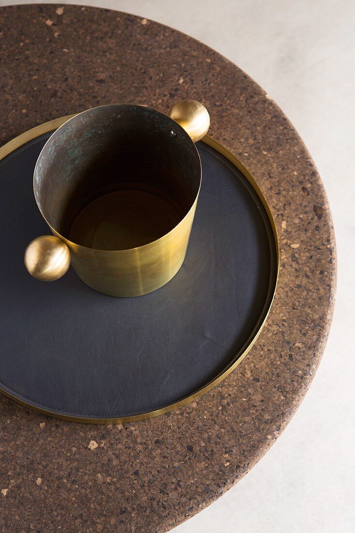 Brass wine cooler and tray on round cork table