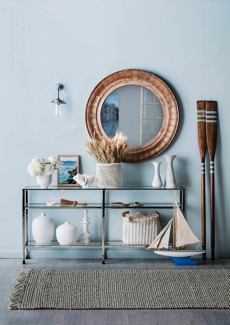 Large round mirror over maritime-decorated console table