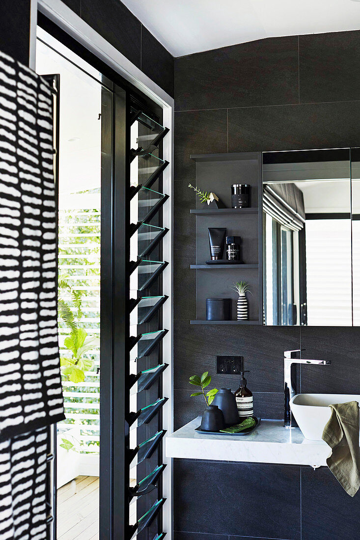 Modernes Bad in Schwarz mit Schieferfliesen und Lamellenfenstern