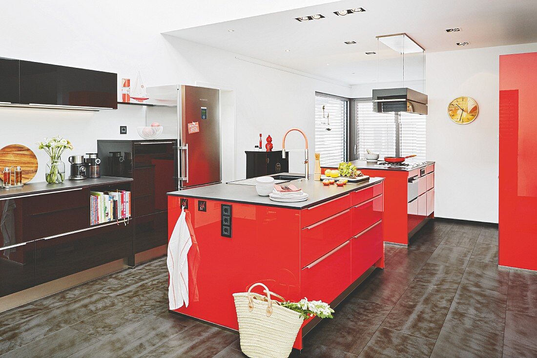 A spacious kitchen with two red kitchen islands and a black unit