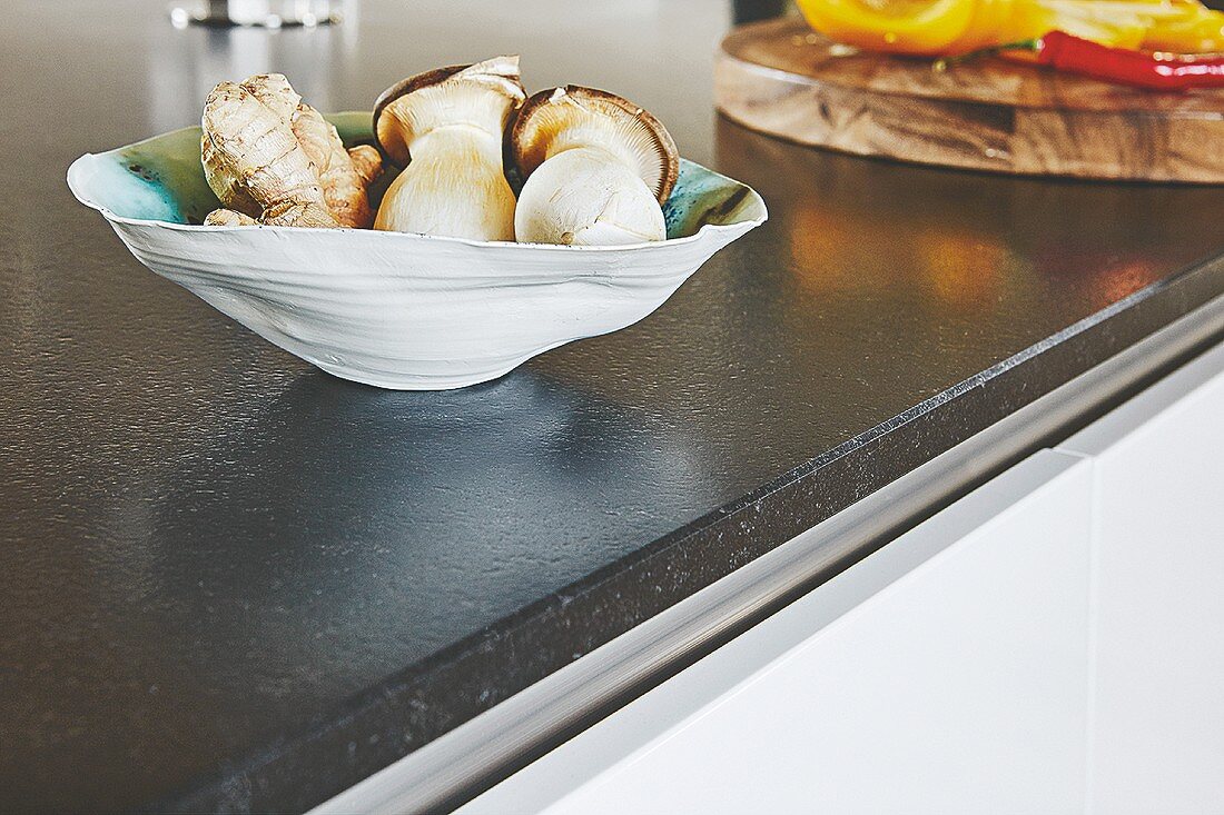 Designerschale mit Pilzen und Ingwer auf Küchenarbeitsplatte