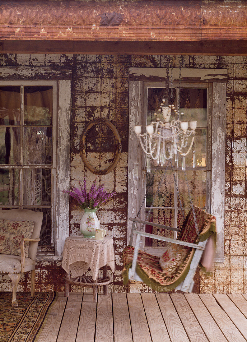 Schaukelbank auf der Veranda eines alten Hauses mit morbidem Charme
