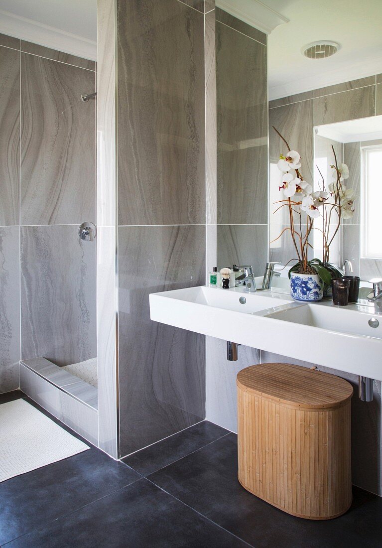 Elegantes Bad mit Duschbereich und weißem Doppelwaschbecken