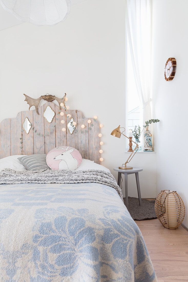 Bed with wooden headboard in child's wintry bedroom