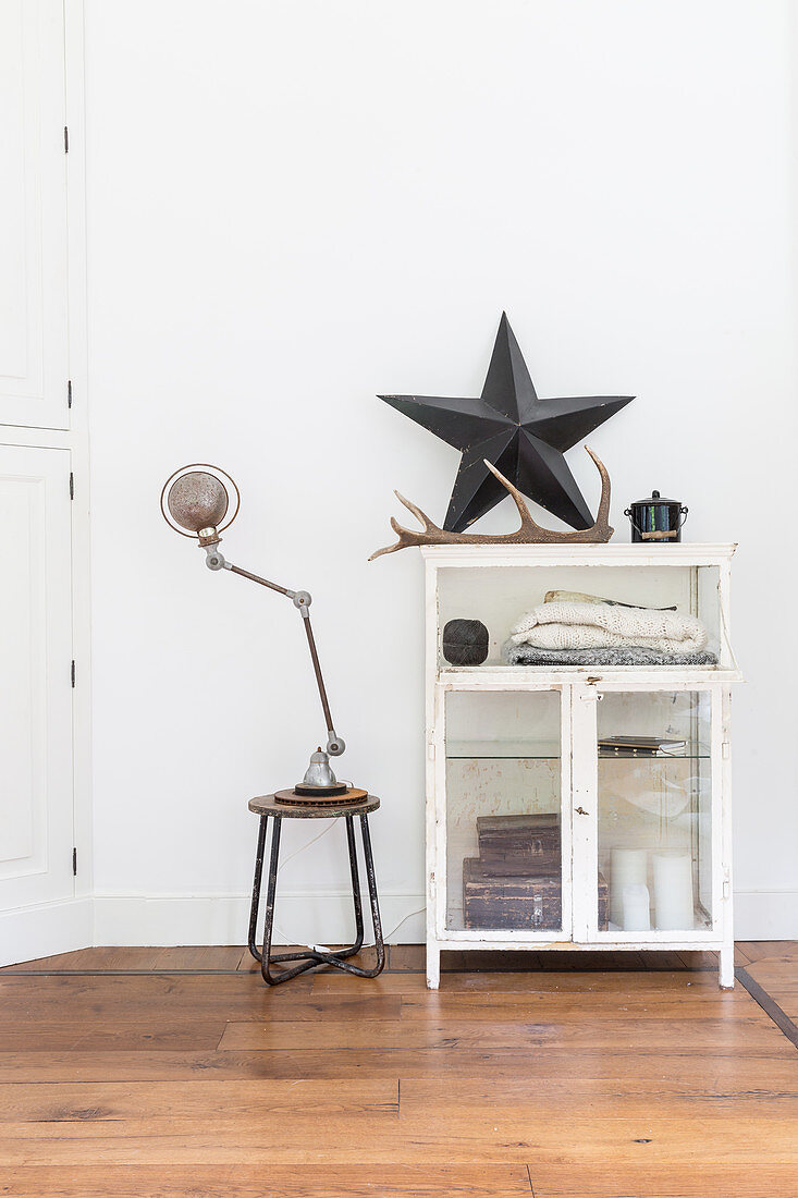 Star and antler on top of old glass-fronted cabinet