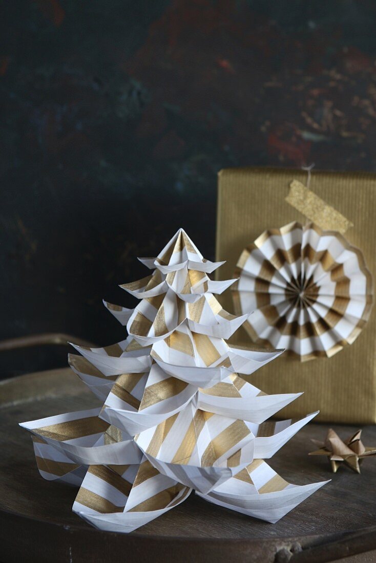 Hand-made paper Christmas tree and gift wrapped in gold paper