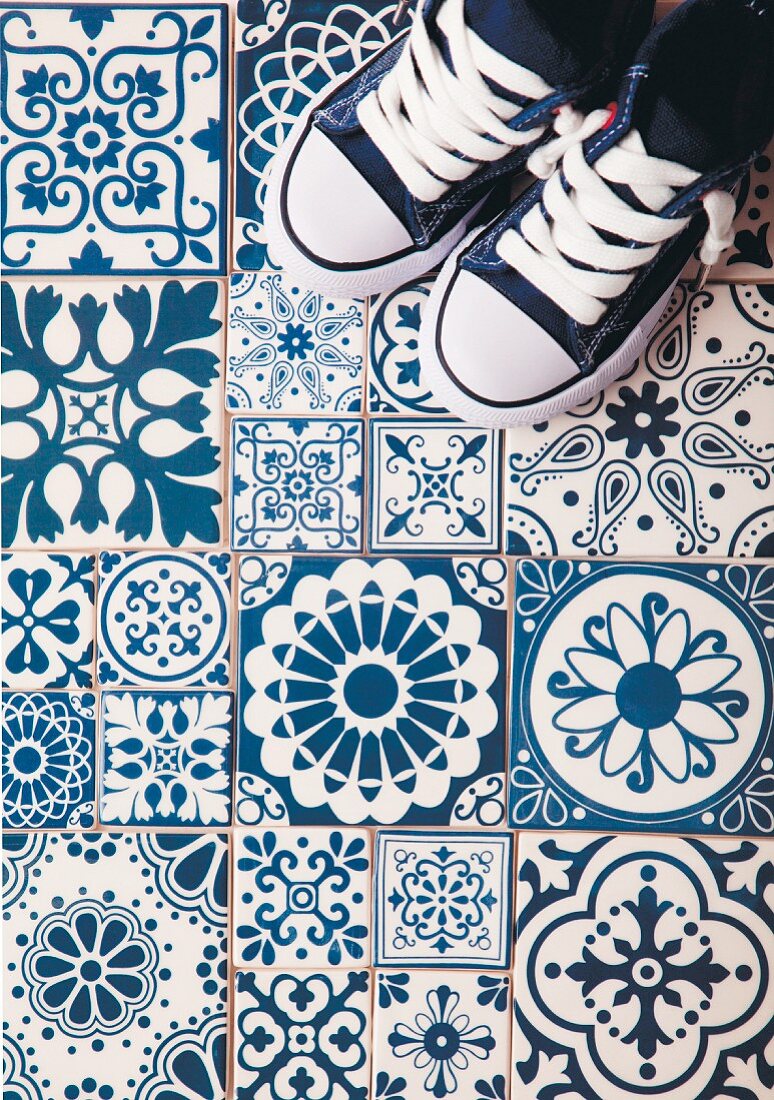 Sneakers on blue and white floor tiles with various patterns