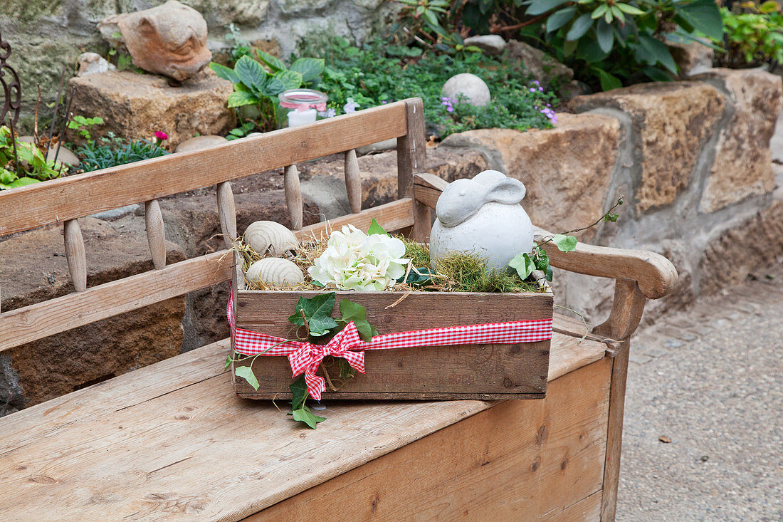 Easter arrangement on wooden bench in garden