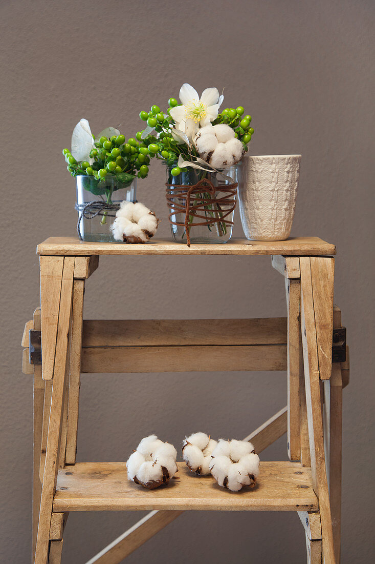 Posies in vases and cotton bolls on ladder