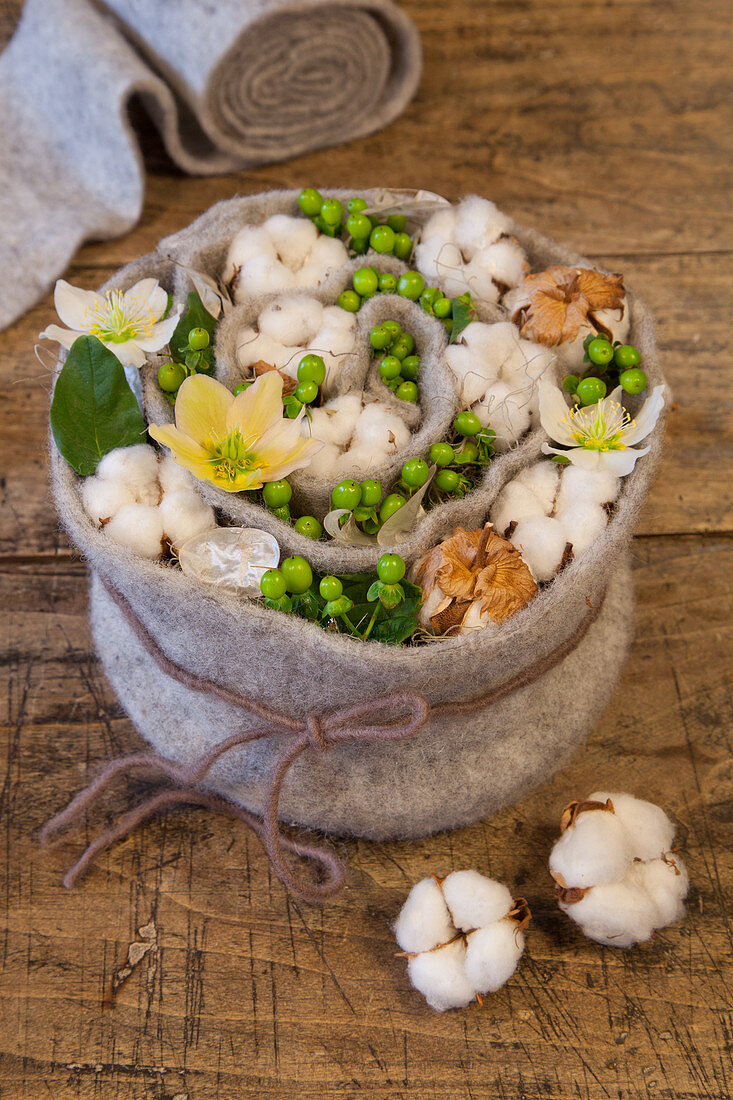 Felt spiral filled with cotton bolls, St. John's wort and hellebores