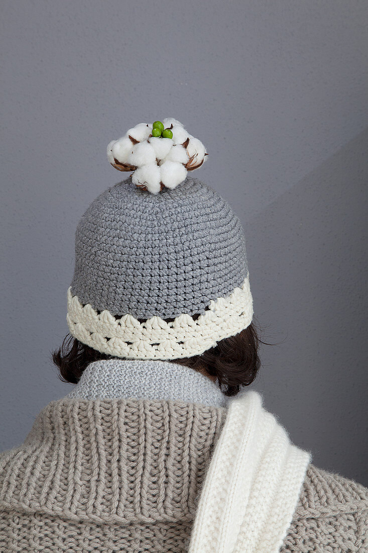 Cotton bolls on top of grey woolly hat with white edge