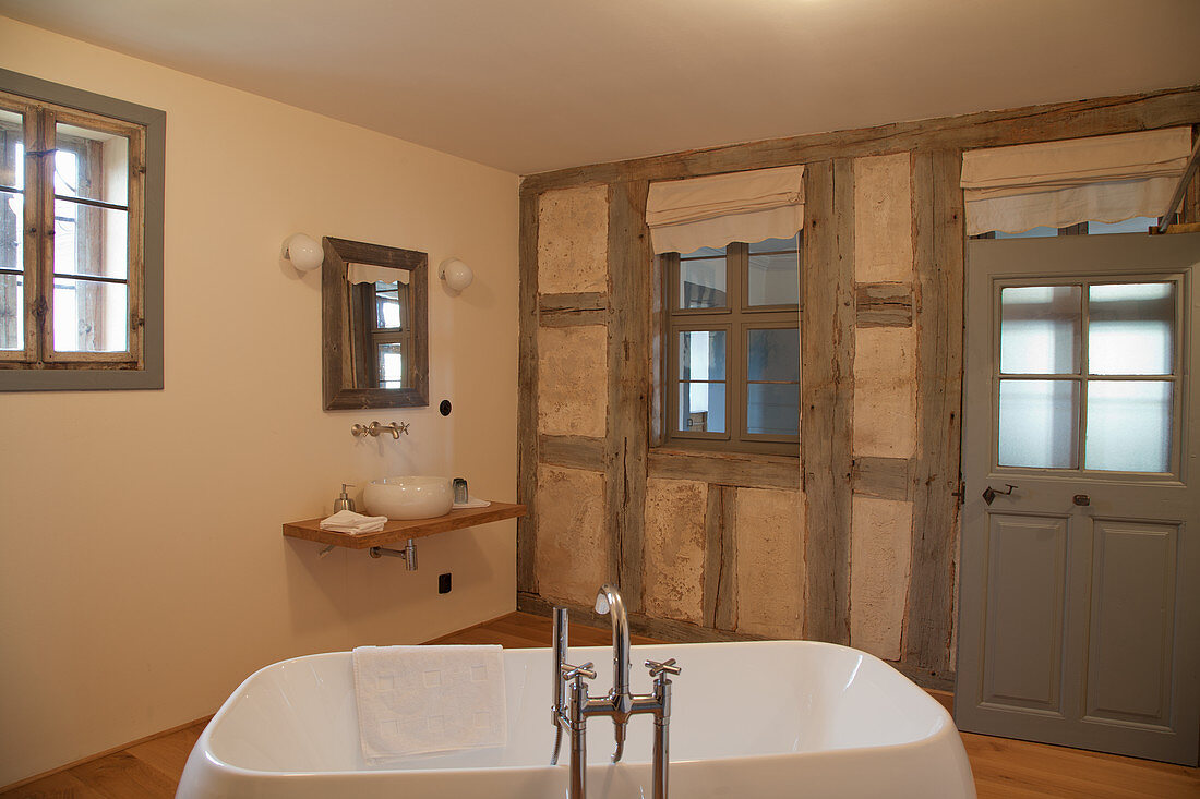Modern bathtub in bathroom with old half-timbered wall