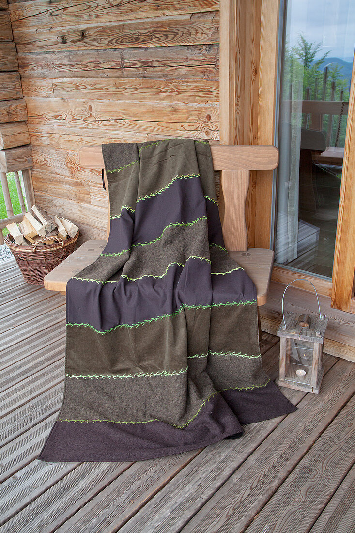 Braune Decke aus verschiedenen Stoffstreifen mit grüner Ziernaht