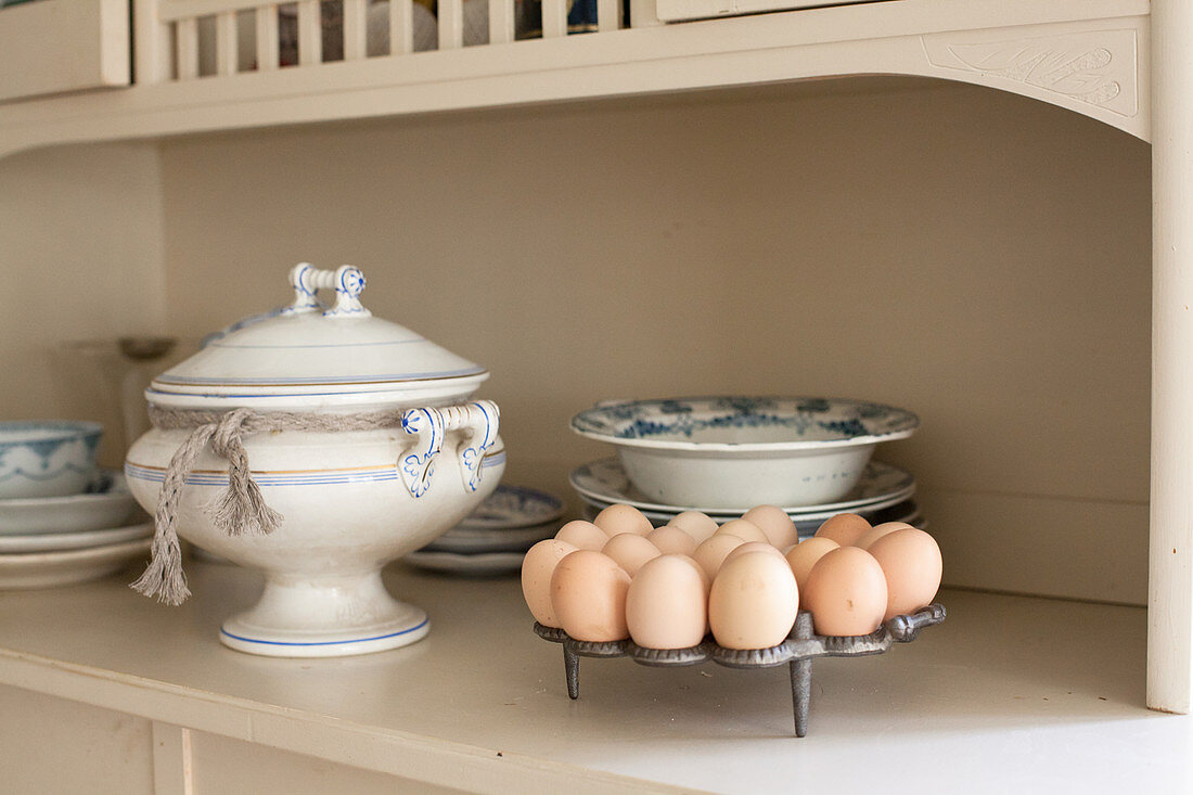 Egg rack, soup tureen and old crockery on kitchen dresser