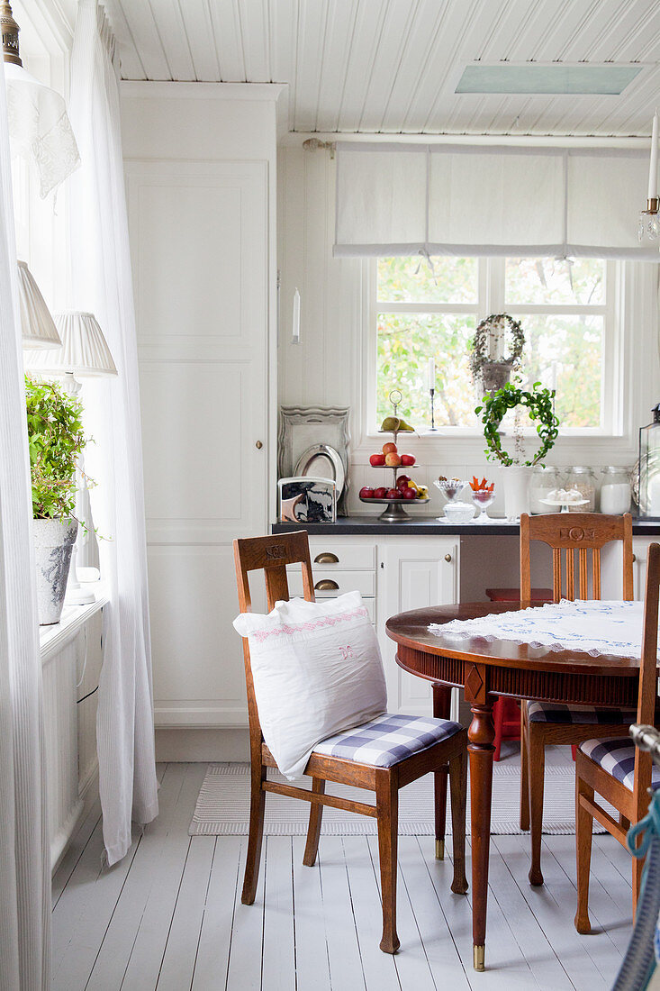 Antiker Tisch und Stühle in skandinavischer Landhausküche
