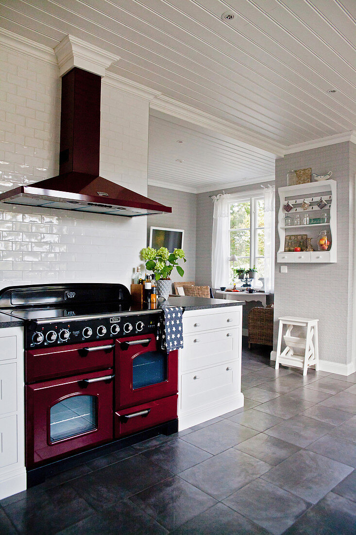 Große Landhausküche in Weiß und Grau mit rotem Küchenofen