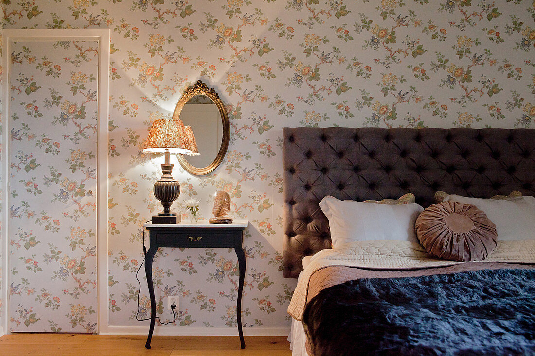 Floral wallpaper on walls and door in vintage-style bedroom